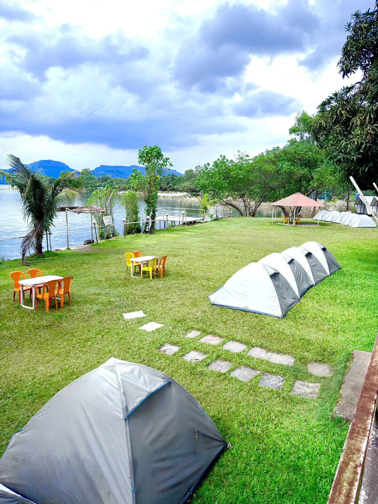 A peaceful lakeside campsite with tents at Pawna Lake